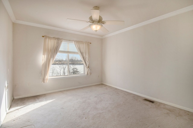 empty room featuring visible vents, baseboards, ornamental molding, and carpet flooring