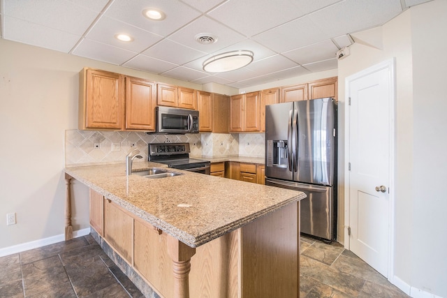 kitchen featuring visible vents, a sink, tasteful backsplash, appliances with stainless steel finishes, and a peninsula