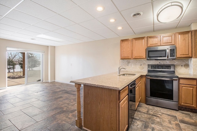 kitchen with visible vents, a sink, appliances with stainless steel finishes, stone finish flooring, and tasteful backsplash