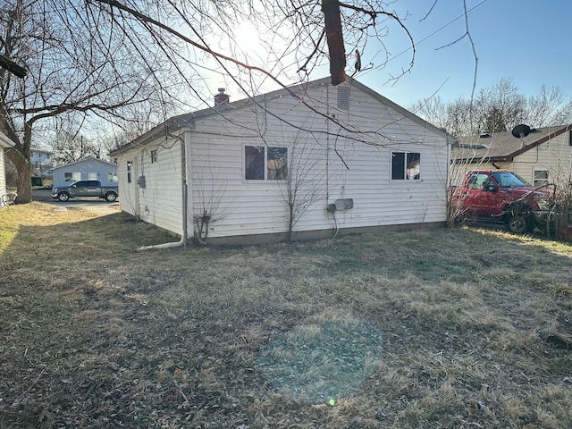 view of home's exterior with a lawn and a chimney