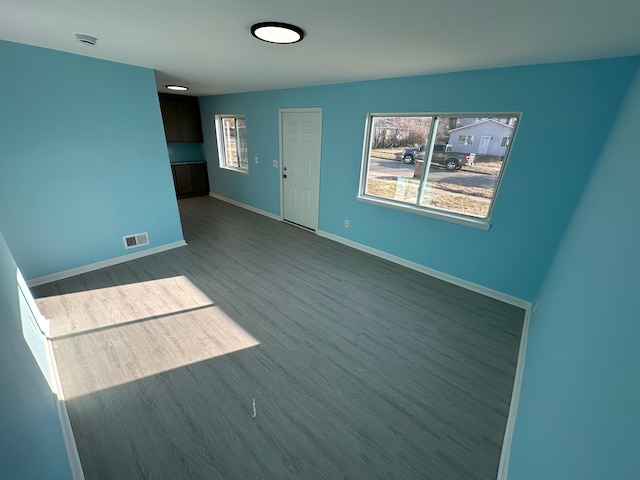 interior space featuring dark wood finished floors, visible vents, and baseboards