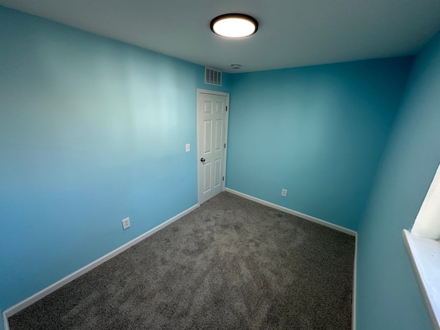 spare room featuring visible vents, carpet flooring, and baseboards