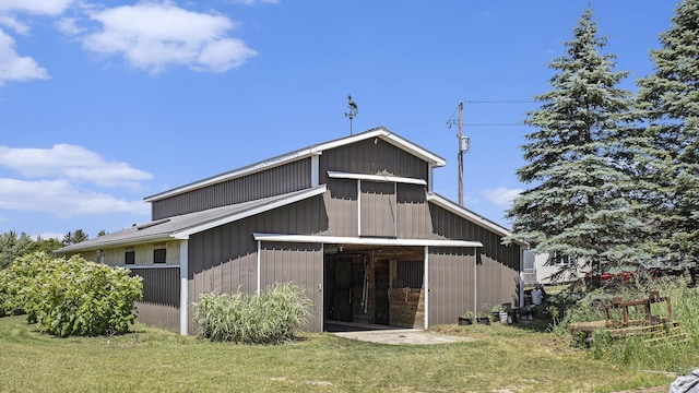 back of house featuring a yard, a barn, and an outdoor structure