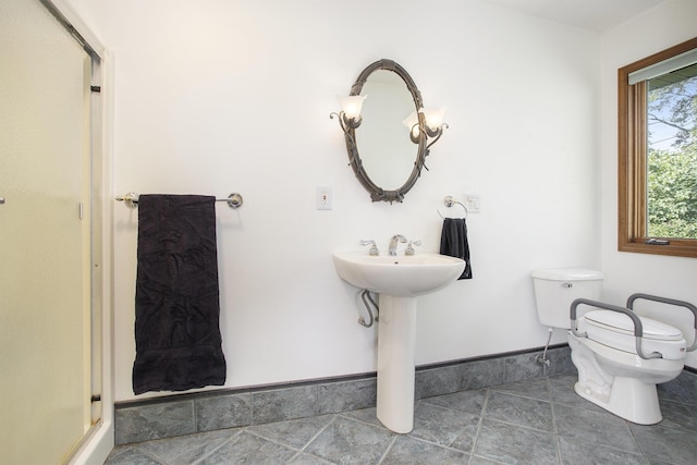 full bath featuring a shower stall, toilet, baseboards, and a sink