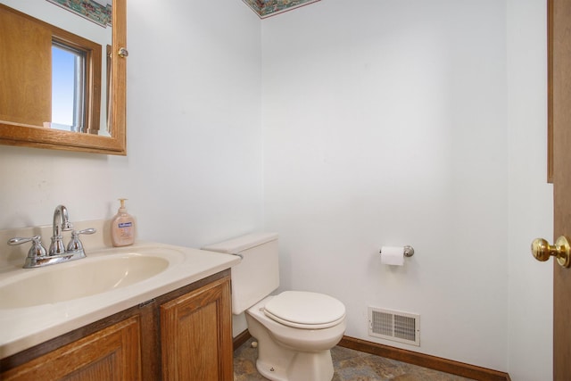 bathroom with vanity, toilet, baseboards, and visible vents