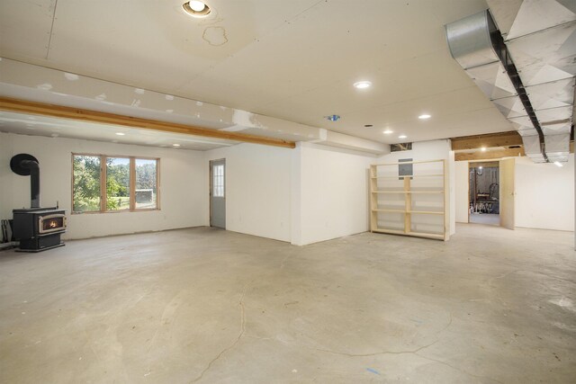 basement with recessed lighting and a wood stove