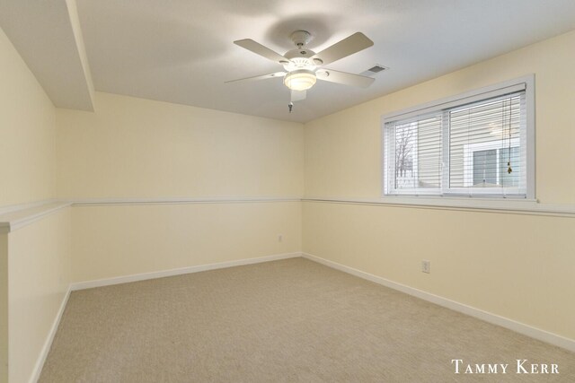 carpeted empty room with visible vents, a ceiling fan, and baseboards