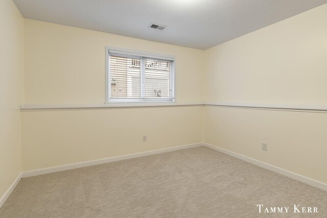 carpeted empty room with visible vents and baseboards