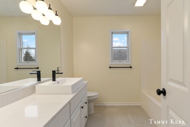 full bathroom with vanity, baseboards, a bathing tub, a shower, and toilet