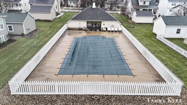 view of swimming pool with a residential view, a lawn, and a fenced backyard