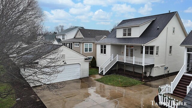 rear view of property featuring stairway, an outbuilding, a garage, and concrete driveway