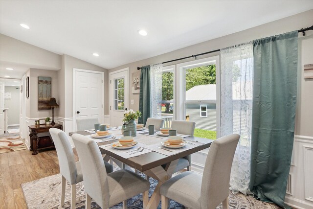 dining room featuring light wood finished floors, recessed lighting, wainscoting, and lofted ceiling