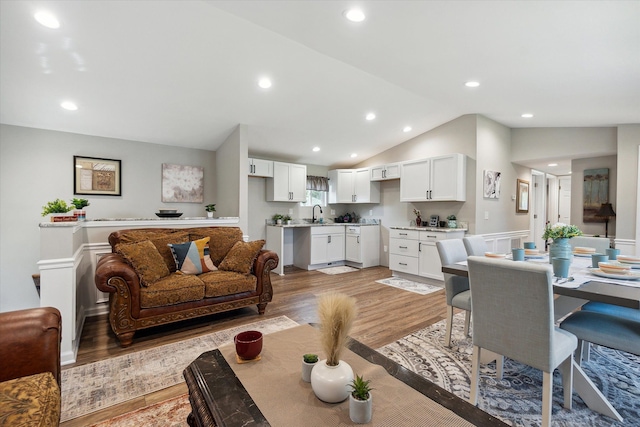 living room with lofted ceiling, recessed lighting, and light wood-style floors