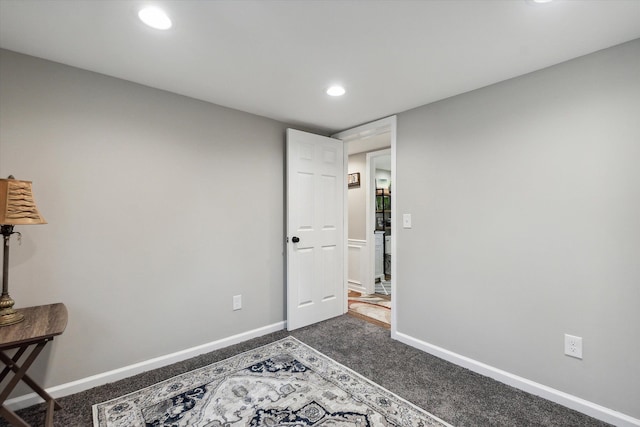 interior space featuring recessed lighting, dark carpet, and baseboards