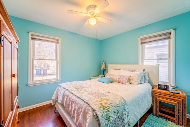 bedroom with ceiling fan, baseboards, and dark wood-style flooring