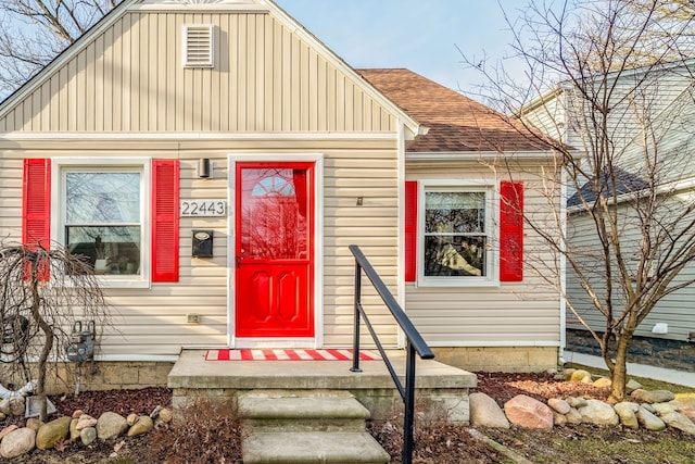 bungalow-style home featuring board and batten siding and a shingled roof