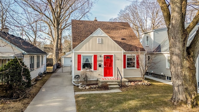 new england style home with an outbuilding, roof with shingles, a chimney, a front lawn, and a garage