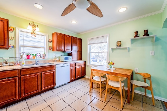 kitchen featuring ornamental molding, white appliances, light countertops, and a sink