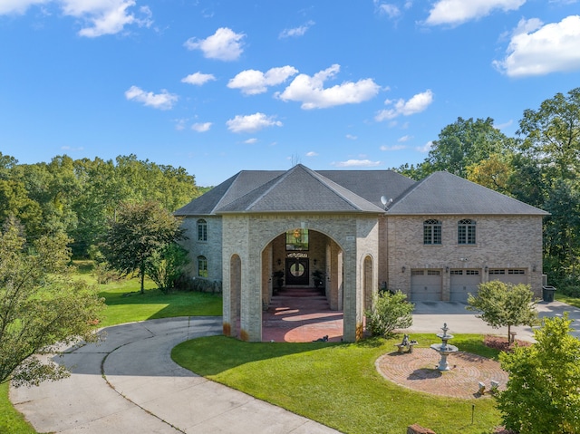 view of front of house with driveway, an attached garage, and a front yard