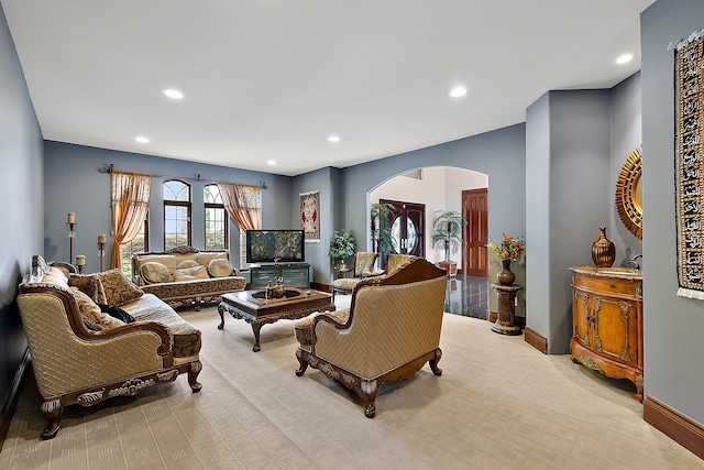 living area with arched walkways, recessed lighting, and baseboards