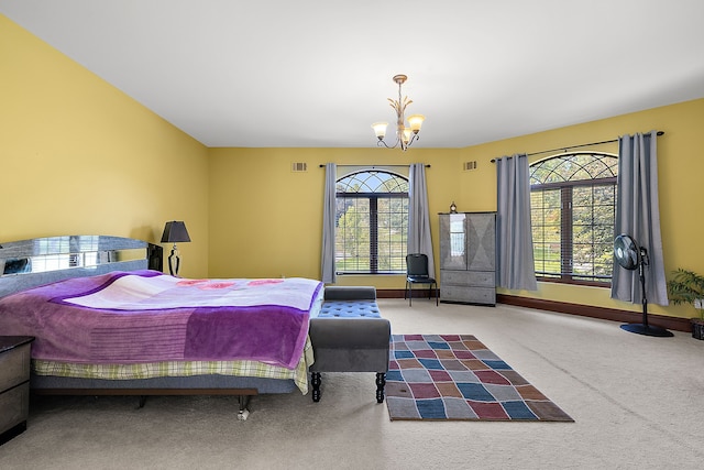 carpeted bedroom featuring a notable chandelier, baseboards, and visible vents