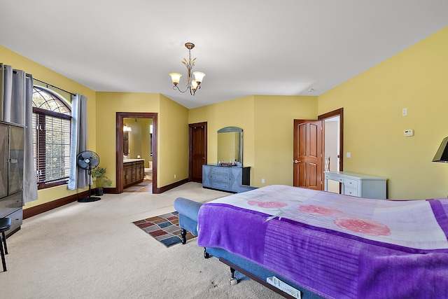 carpeted bedroom with ensuite bath, a notable chandelier, and baseboards