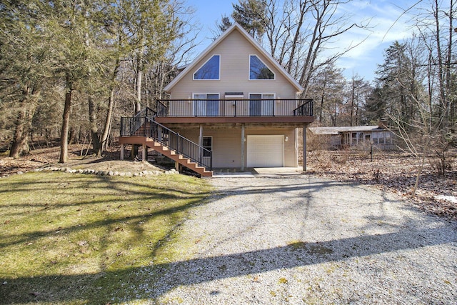 view of front of home featuring driveway, stairs, a front lawn, a garage, and a deck