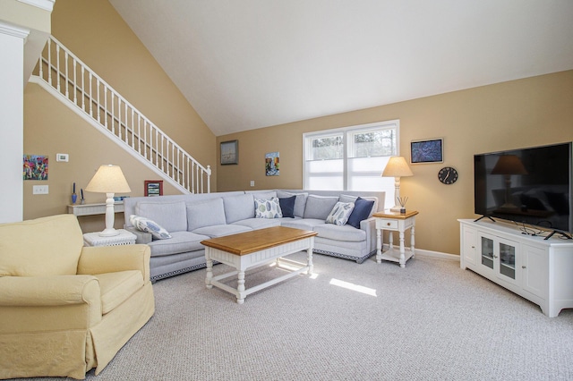 living room featuring stairs, light colored carpet, and baseboards