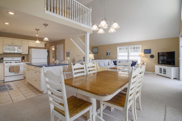 dining room with light carpet, a notable chandelier, recessed lighting, stairway, and a towering ceiling