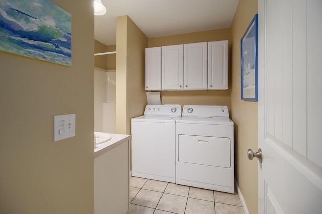 laundry room with light tile patterned floors, cabinet space, and independent washer and dryer