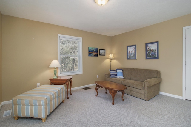 living area featuring visible vents, baseboards, and light colored carpet