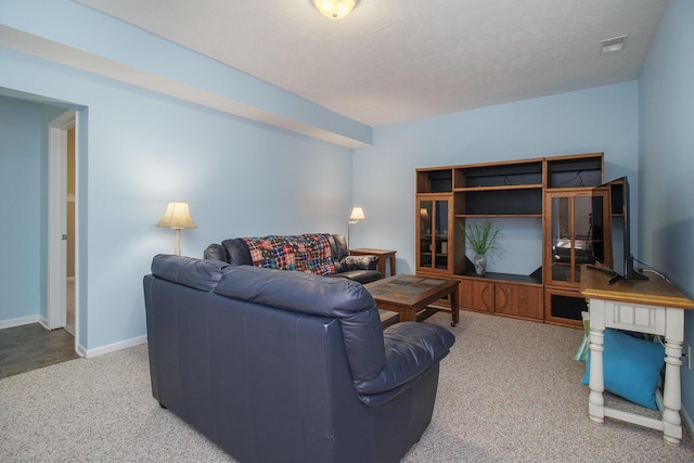 carpeted living area featuring visible vents, a textured ceiling, and baseboards