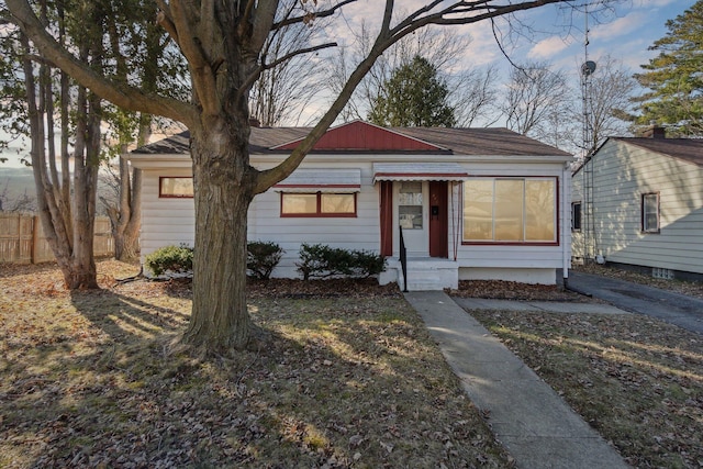 bungalow-style home featuring fence