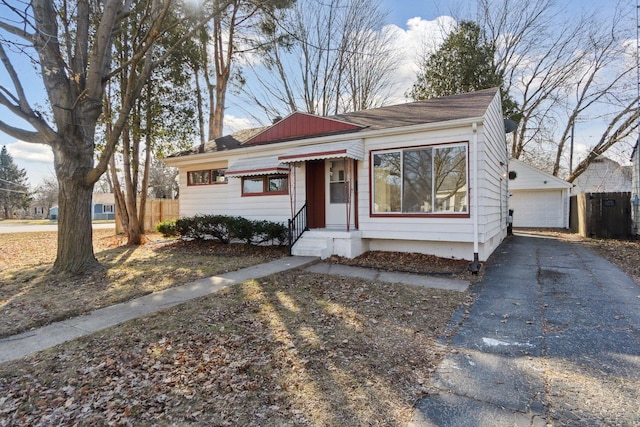 bungalow with a detached garage and fence