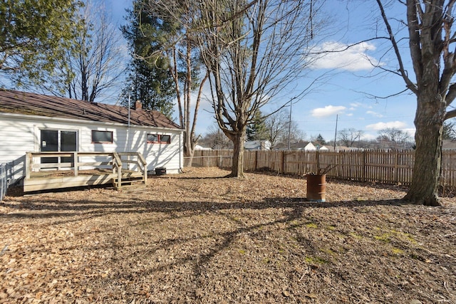 view of yard featuring a wooden deck and fence