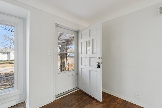 foyer entrance with visible vents, baseboards, and dark wood-style flooring