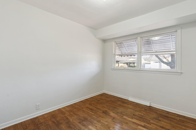 unfurnished room with visible vents, baseboards, and dark wood-style floors