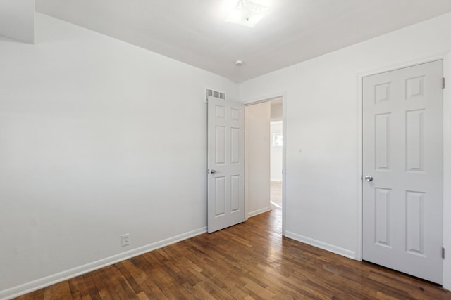 unfurnished bedroom featuring visible vents, baseboards, and wood finished floors