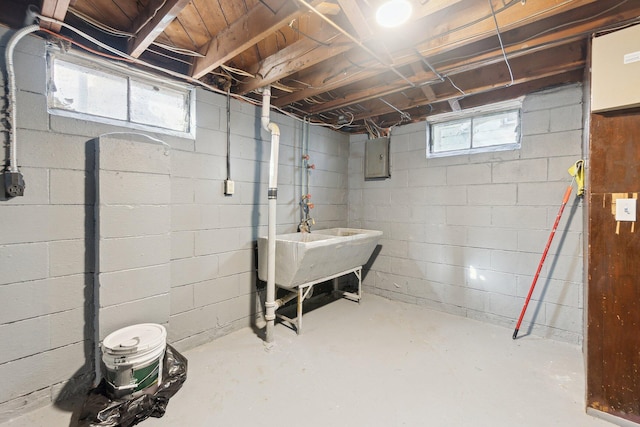 basement with electric panel and a sink