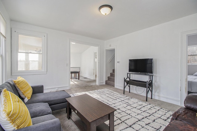 living room with stairway, carpet floors, and baseboards