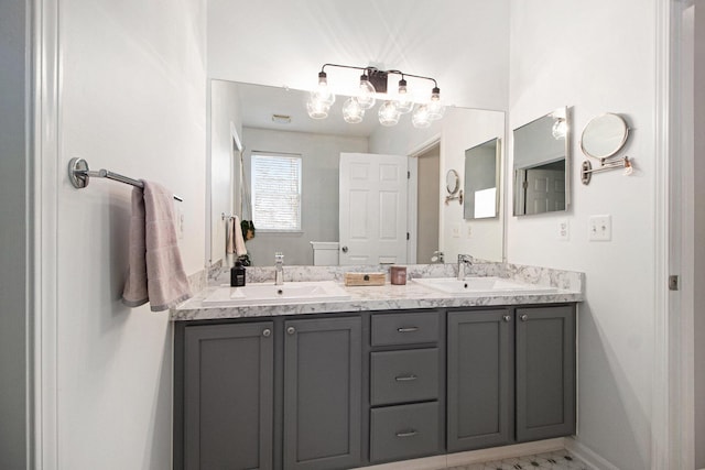 full bathroom featuring double vanity, marble finish floor, baseboards, and a sink