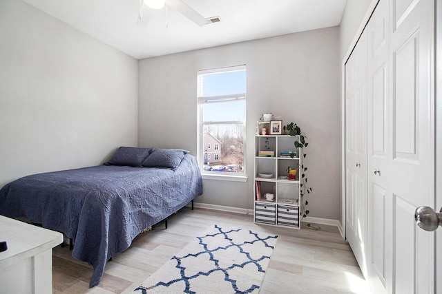 bedroom with visible vents, baseboards, light wood-style flooring, a closet, and a ceiling fan