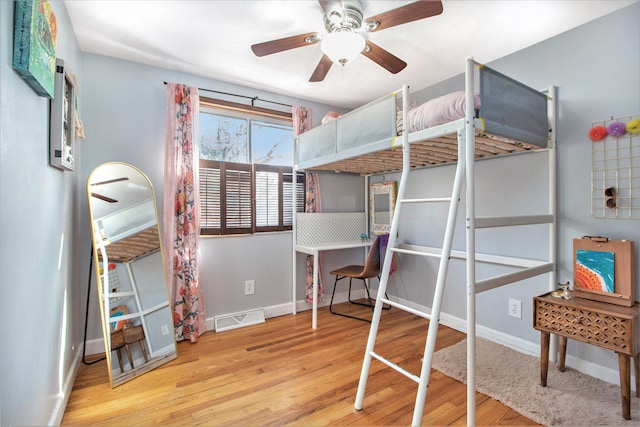 bedroom with visible vents, baseboards, and wood finished floors