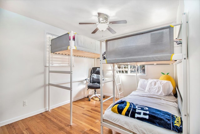 bedroom featuring a ceiling fan, baseboards, and wood finished floors