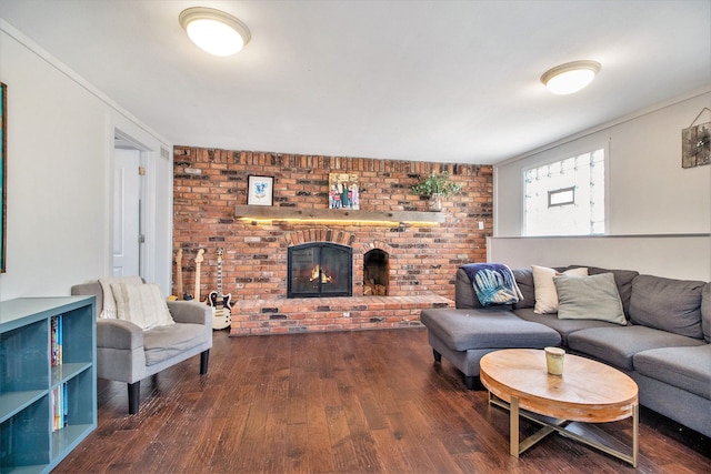 living room with a brick fireplace, wood finished floors, and brick wall