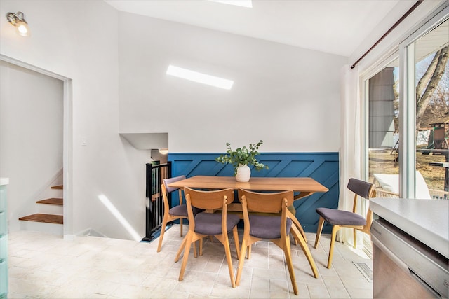 dining room featuring a wainscoted wall and stairway