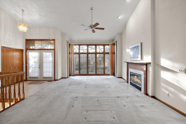 unfurnished living room featuring a ceiling fan, carpet flooring, a fireplace, and high vaulted ceiling