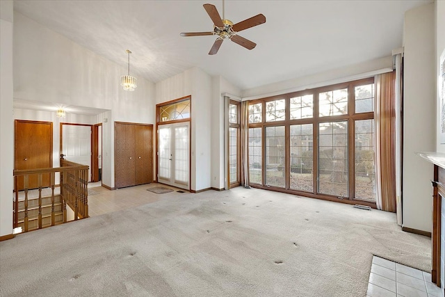 unfurnished living room featuring baseboards, carpet floors, high vaulted ceiling, and ceiling fan with notable chandelier