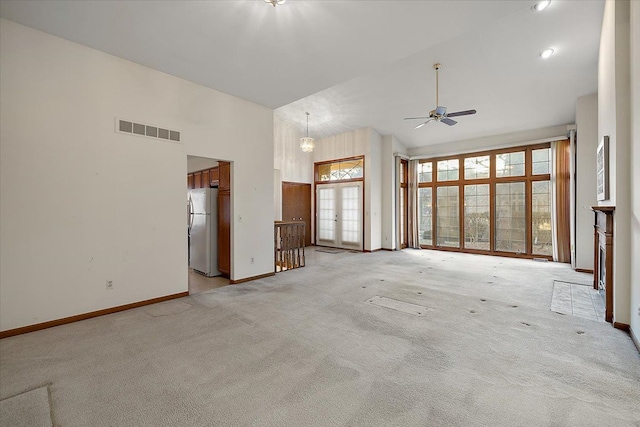 unfurnished living room with visible vents, baseboards, light carpet, high vaulted ceiling, and a ceiling fan