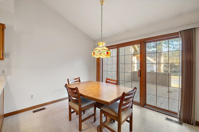 dining room featuring vaulted ceiling, baseboards, visible vents, and light floors